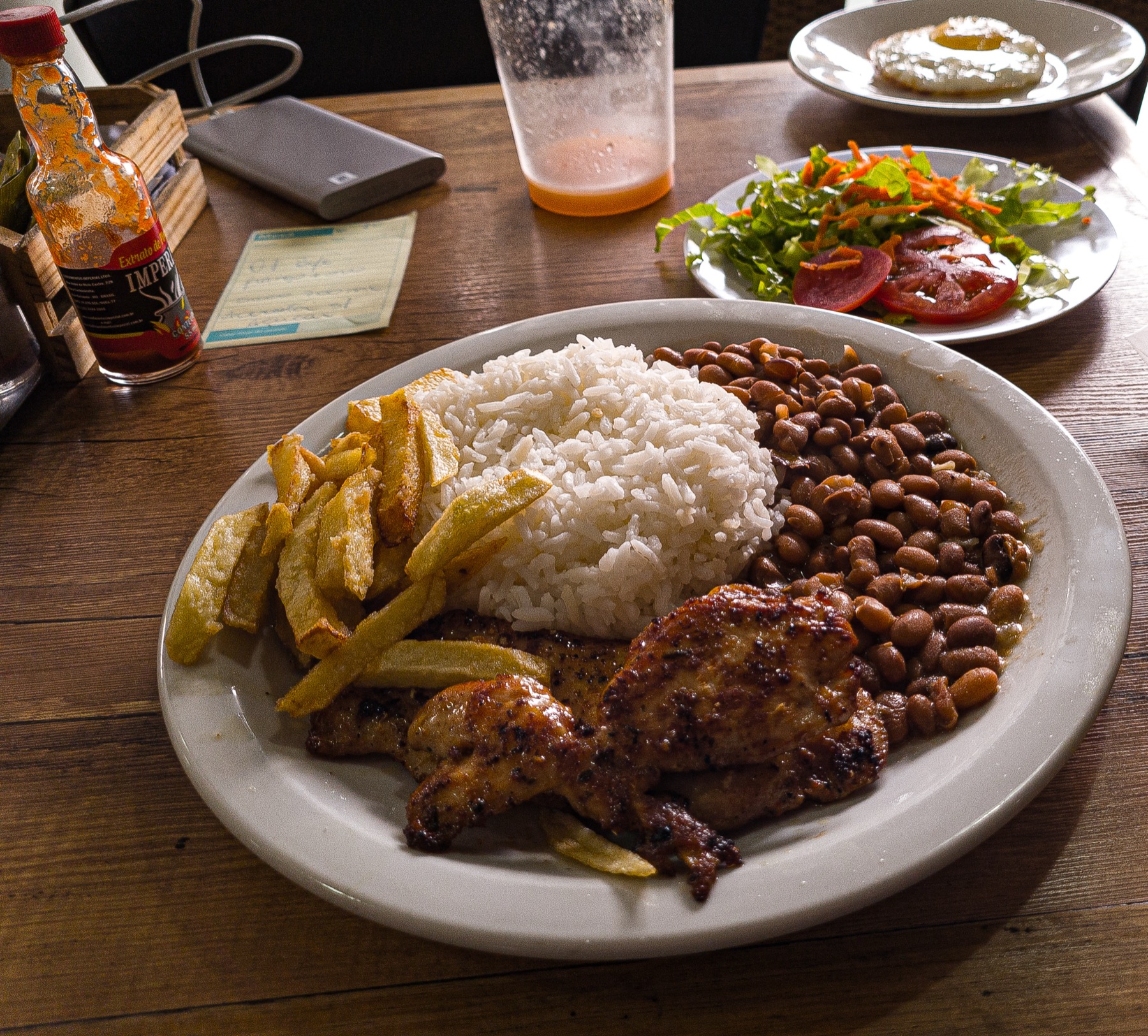 Grilled chicken rice beans salad and sides arranged on a full plate for a buffet-style meal